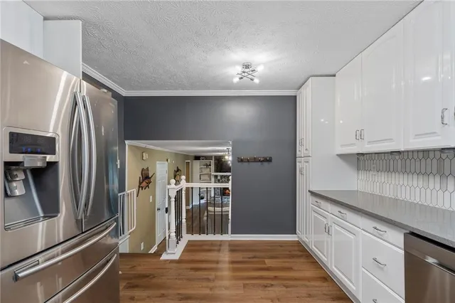 a kitchen with granite countertop a refrigerator and a sink