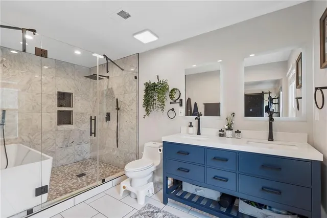 a bathroom with a granite countertop sink a toilet and shower