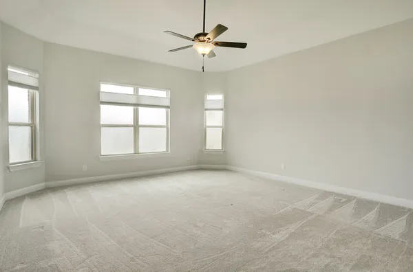 an empty room with a ceiling fan and window