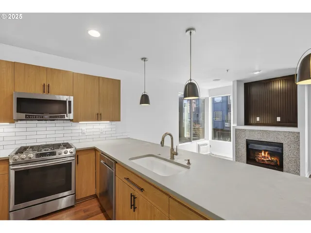 a kitchen with stainless steel appliances a stove a sink and a microwave