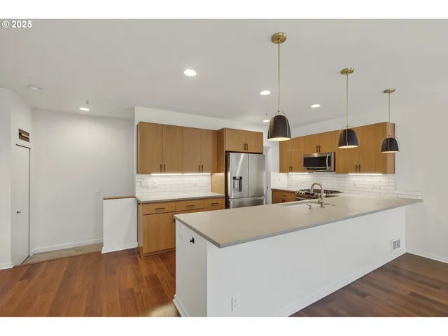 a kitchen with stainless steel appliances granite countertop a sink a stove and a refrigerator