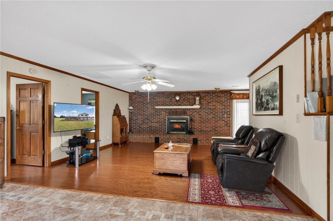 145 State Rd S-4-935 Pendleton, SC 29670 - Photo 40 of 47 Warm wood flooring extends throughout this inviting living area, anchored by a prominent brick fireplace.
