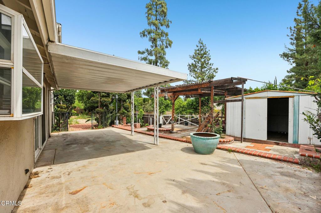10856 Topeka Drive Porter Ranch, CA 91326 - Photo 34 of 39 a view of a patio with a table and chairs under an umbrella