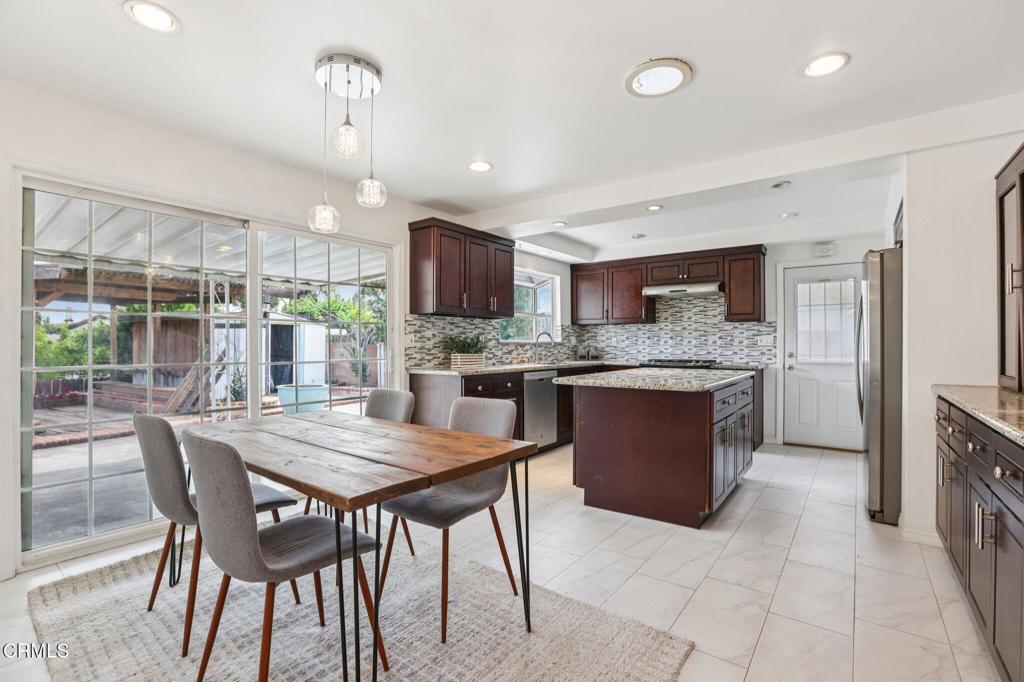 10856 Topeka Drive Porter Ranch, CA 91326 - Photo 9 of 39 a kitchen with stainless steel appliances granite countertop a stove a sink a oven a dining table and chairs