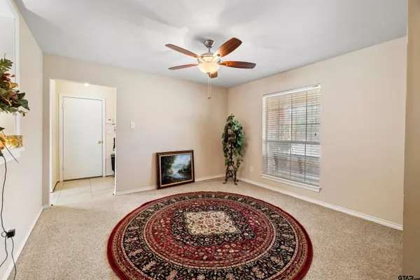 an empty room with windows and ceiling fan