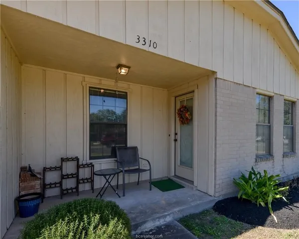 a view of a porch with chairs and potted plants