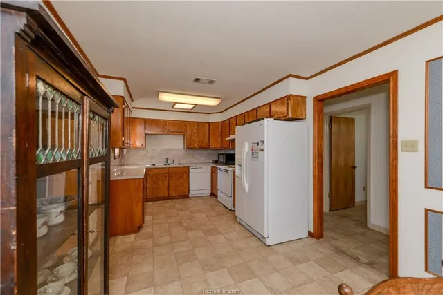 a kitchen with refrigerator and white cabinets