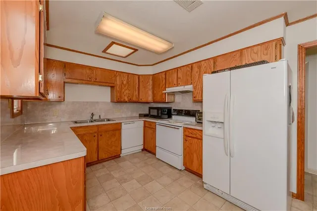 a kitchen with stainless steel appliances granite countertop a refrigerator and a stove top oven