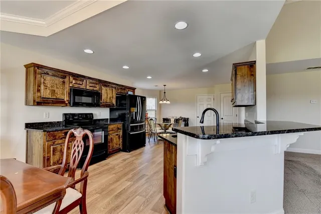 a kitchen with stainless steel appliances granite countertop a sink and a refrigerator