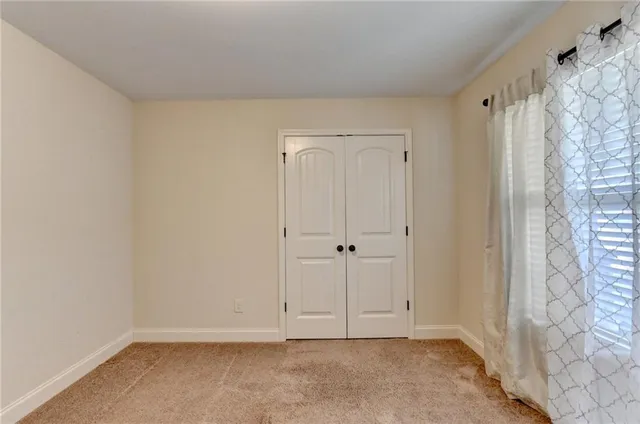 a bathroom with a granite countertop sink a toilet and a mirror