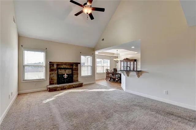 a view of a livingroom with a fireplace a window and a chandelier