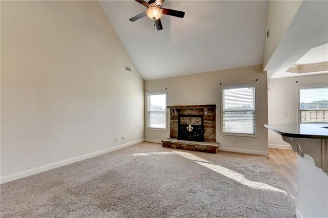 an empty room with fireplace and windows