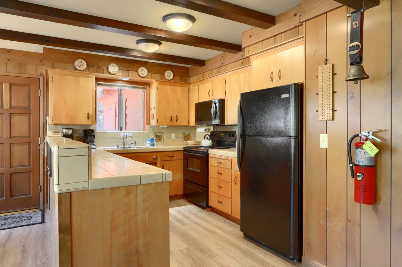 8067 Chilnualna Falls Road Wawona, CA 95389 - Photo 13 of 42 a kitchen with stainless steel appliances granite countertop a refrigerator and a sink