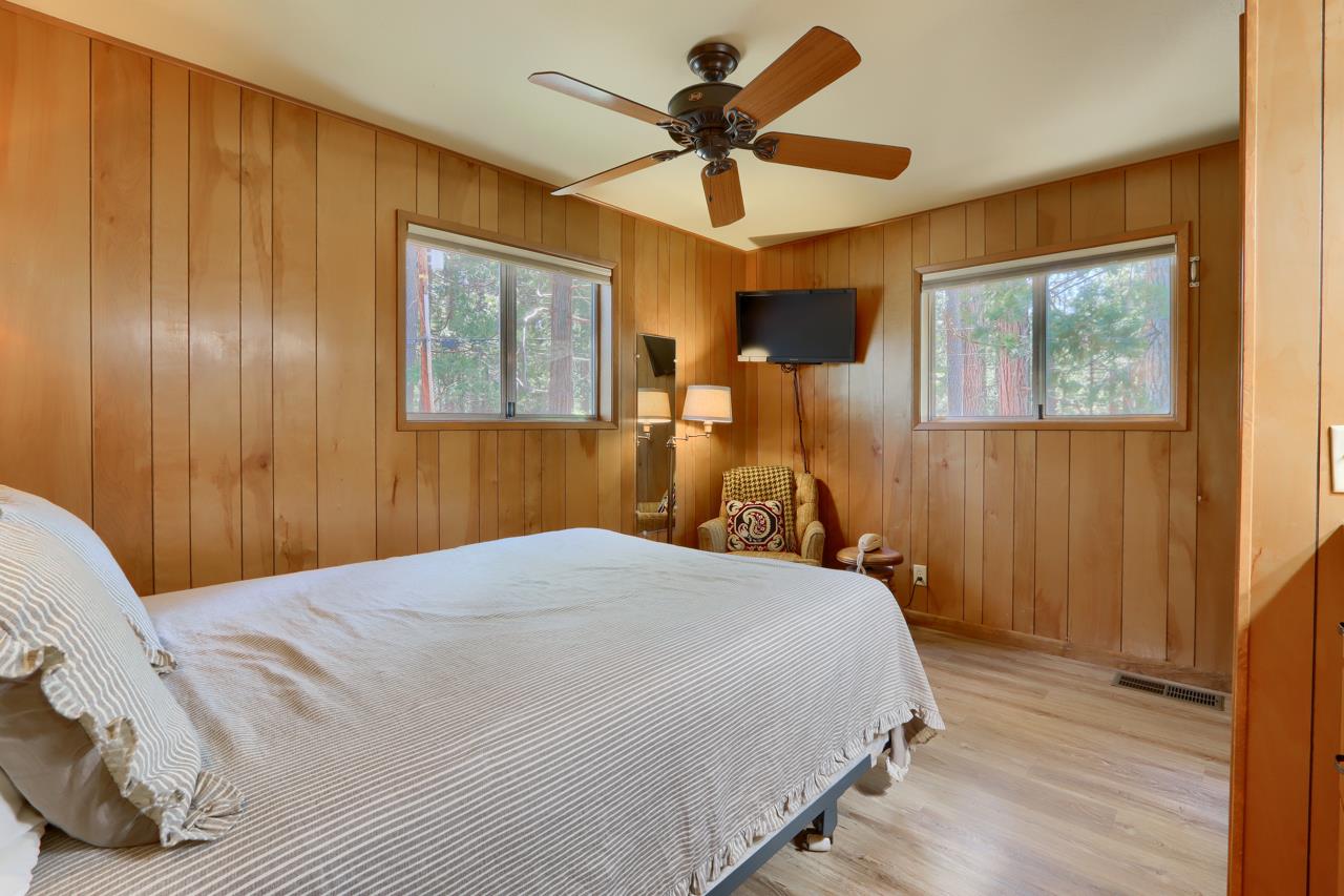8067 Chilnualna Falls Road Wawona, CA 95389 - Photo 20 of 42 a bedroom with a bed and a chandelier