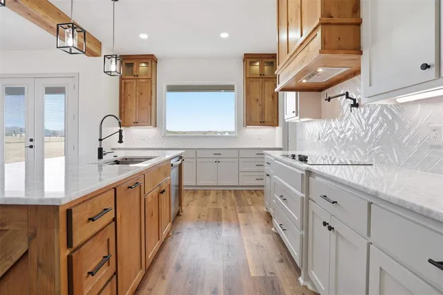 a large kitchen with stainless steel appliances kitchen island granite countertop a sink and wooden cabinets