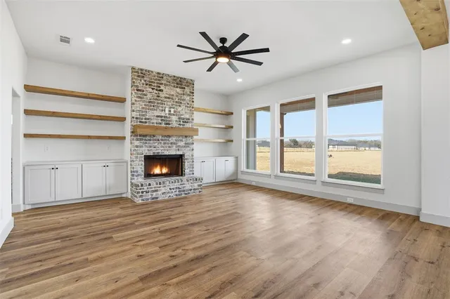 a view of an empty room with a fireplace and a window