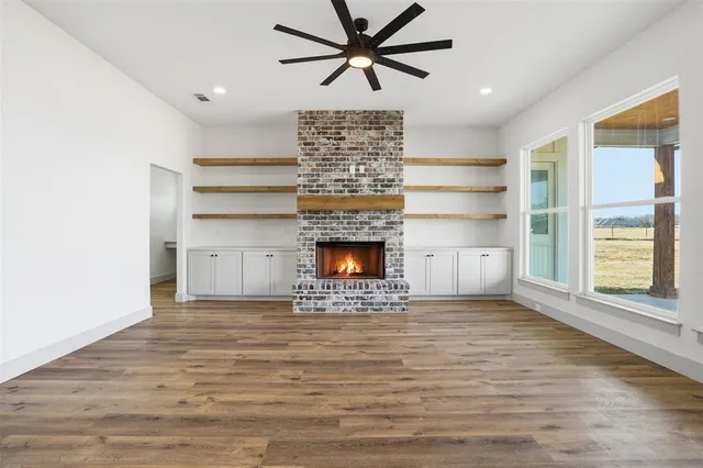 a view of a room with natural light and a fireplace