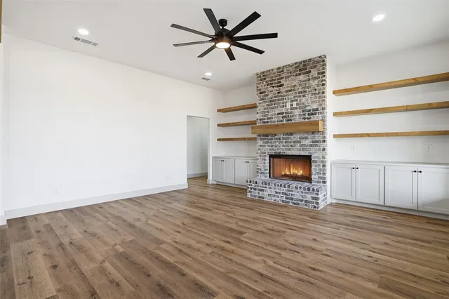 a view of an empty room with a fireplace and a window