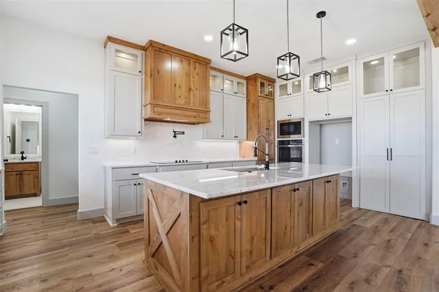 a kitchen with stainless steel appliances granite countertop a sink a stove and a refrigerator