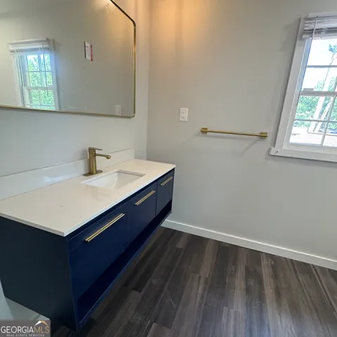 a room with a wooden floor and windows