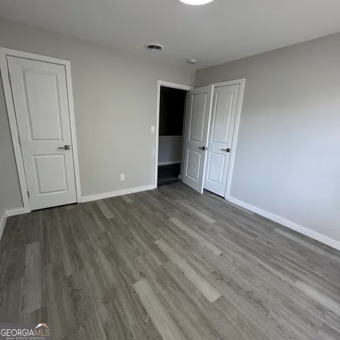 a view of an empty room with wooden floor