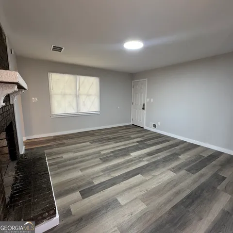 a view of a livingroom with wooden floor and a window
