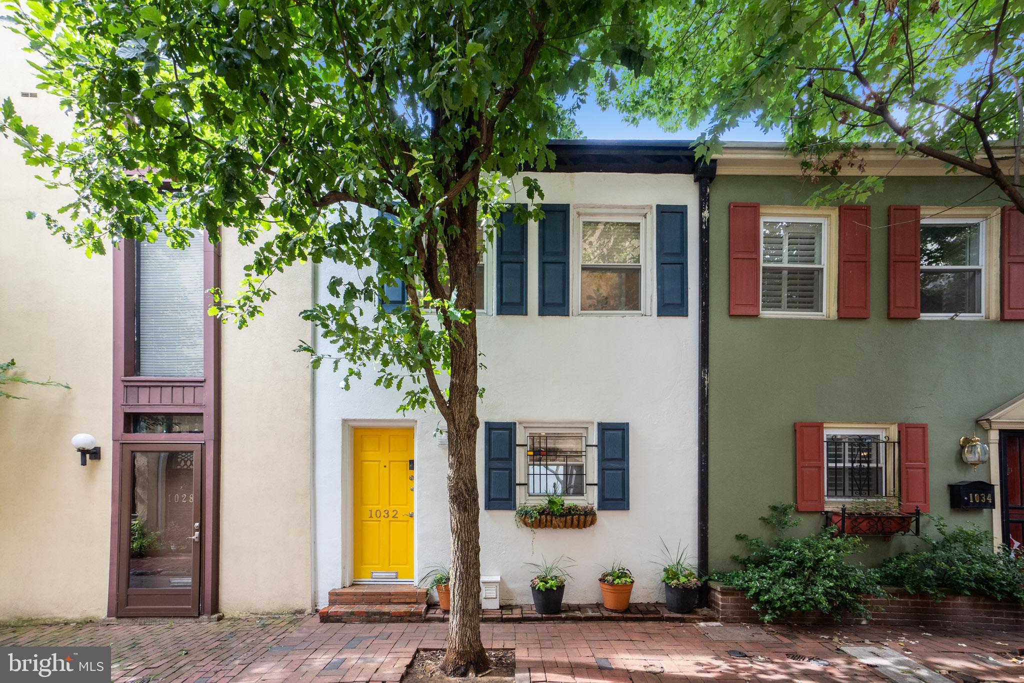 a front view of a house with a tree