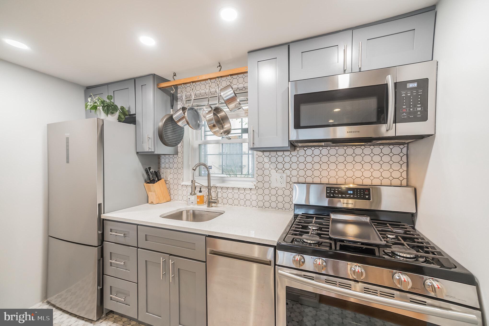 1032 Waverly Street Philadelphia, PA 19147 - Photo 10 of 30 a kitchen with stainless steel appliances granite countertop a refrigerator stove and microwave