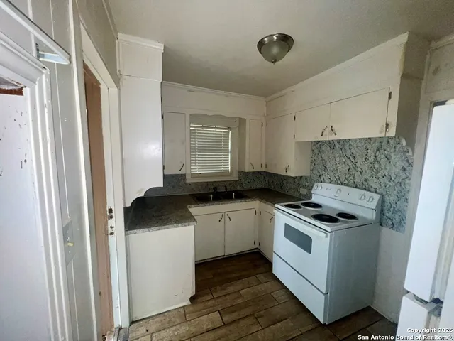 a kitchen with a stove sink and cabinets