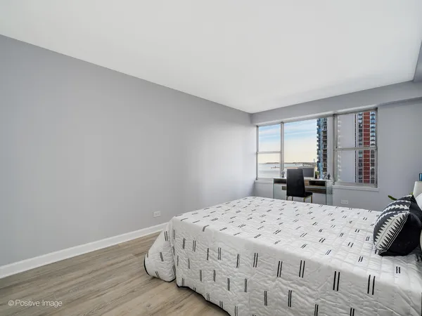 a bedroom with a large bed and wooden floor