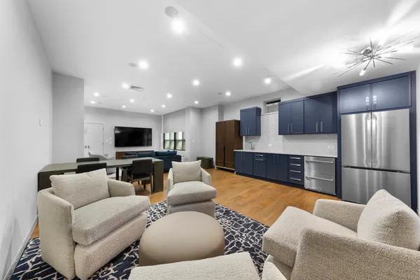 a living room with furniture kitchen and a flat screen tv