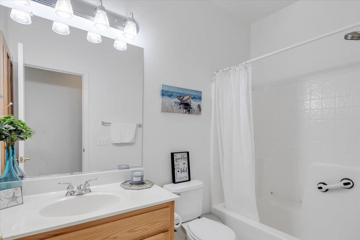 6250 Bluff View Road, Unit 60 Copperopolis, CA 95228 - Photo 34 of 75 a bathroom with a granite countertop sink a toilet and a mirror