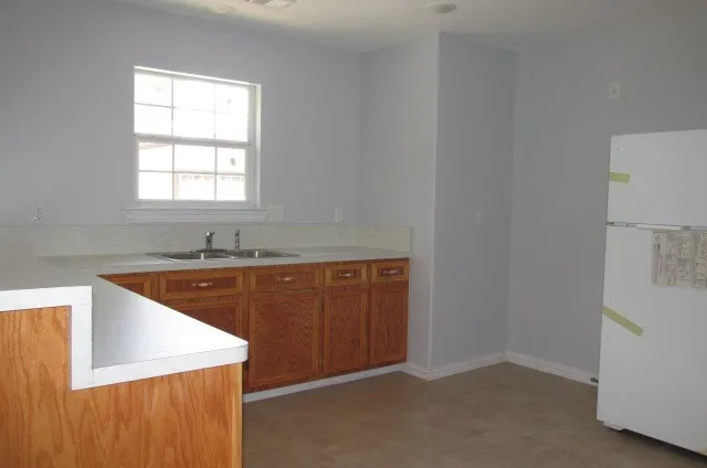 a room with a sink cabinets and a window