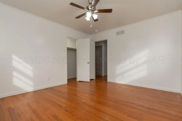 a view of an empty room with wooden floor