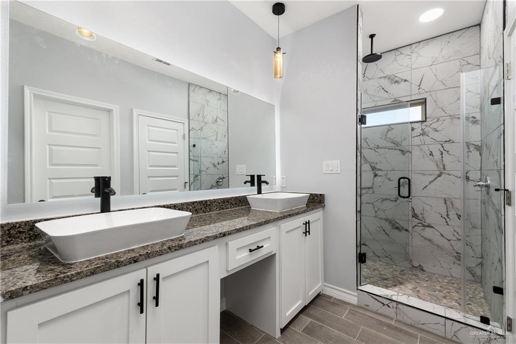 1271 Stirrup Circle San Benito, TX 78586 - Photo 10 of 18 a bathroom with a granite countertop sink a mirror and shower
