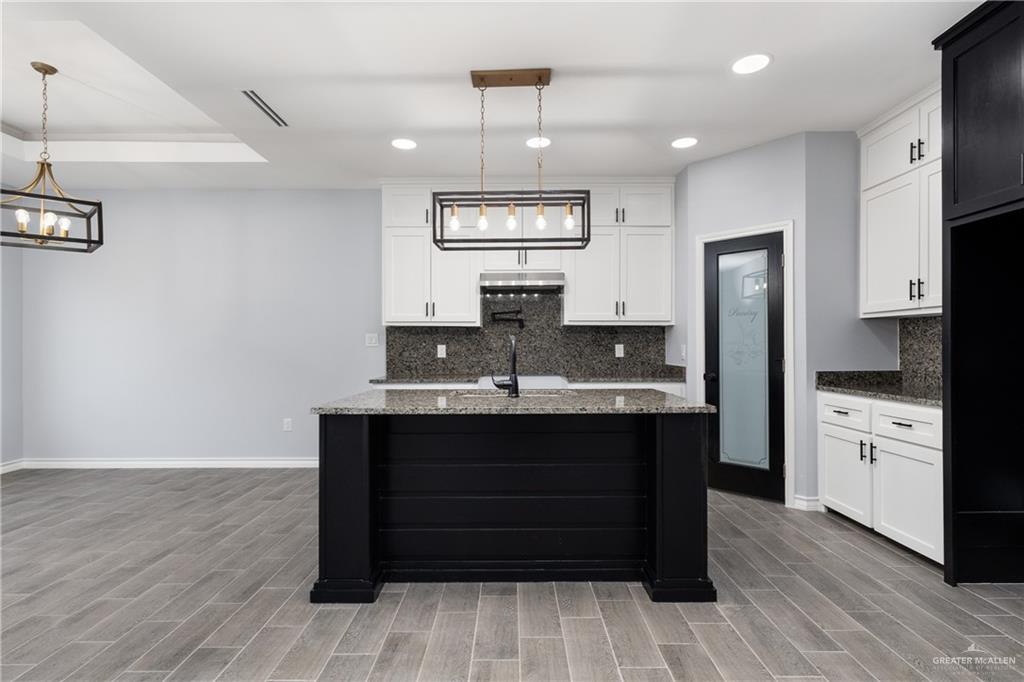1271 Stirrup Circle San Benito, TX 78586 - Photo 3 of 18 a view of cabinets a kitchen island wooden floors stainless steel appliances and window