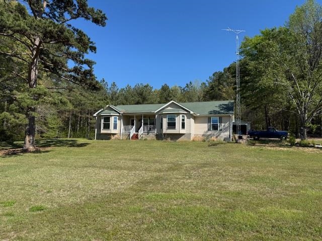 View of front of property with covered porch and a front lawn