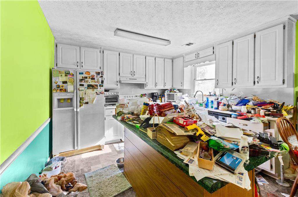 125 Laurel Way Covington, GA 30016 - Photo 11 of 21 a view of a kitchen with refrigerator and a stove