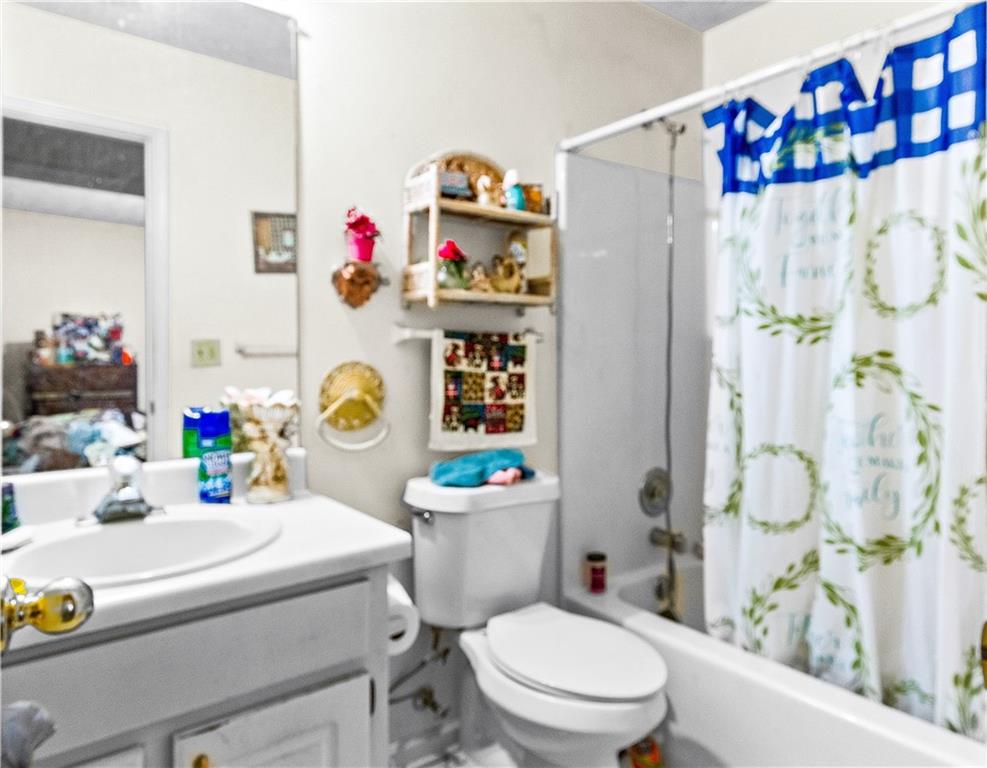 125 Laurel Way Covington, GA 30016 - Photo 20 of 21 a bathroom with a sink a toilet and a shower curtain