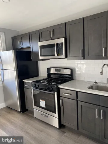 a kitchen with stainless steel appliances a stove microwave and refrigerator