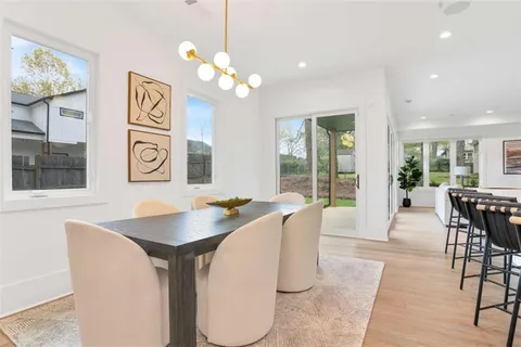 a dining room with wooden floor a chandelier a wooden table and chairs