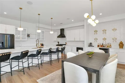 a view of a dining room and livingroom with furniture wooden floor a chandelier
