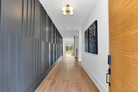 a view of a hallway with wooden floor and staircase