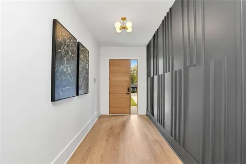 a view of a hallway with wooden floor and a bathroom