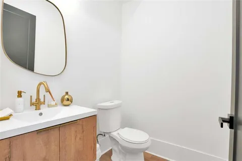 a bathroom with a toilet sink and mirror