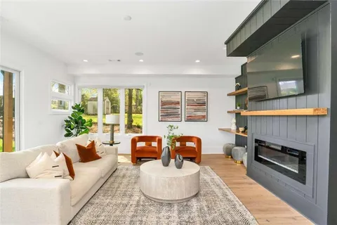 a living room with furniture a large window and a fireplace