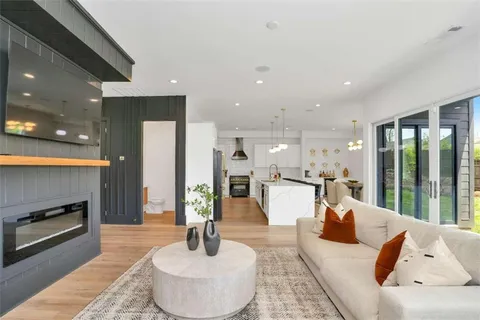 a living room with fireplace furniture and a large window