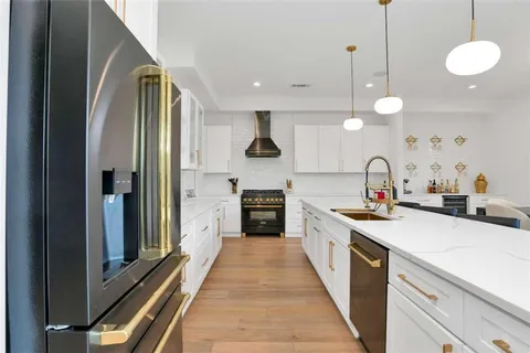a large kitchen with stainless steel appliances a stove sink and cabinets