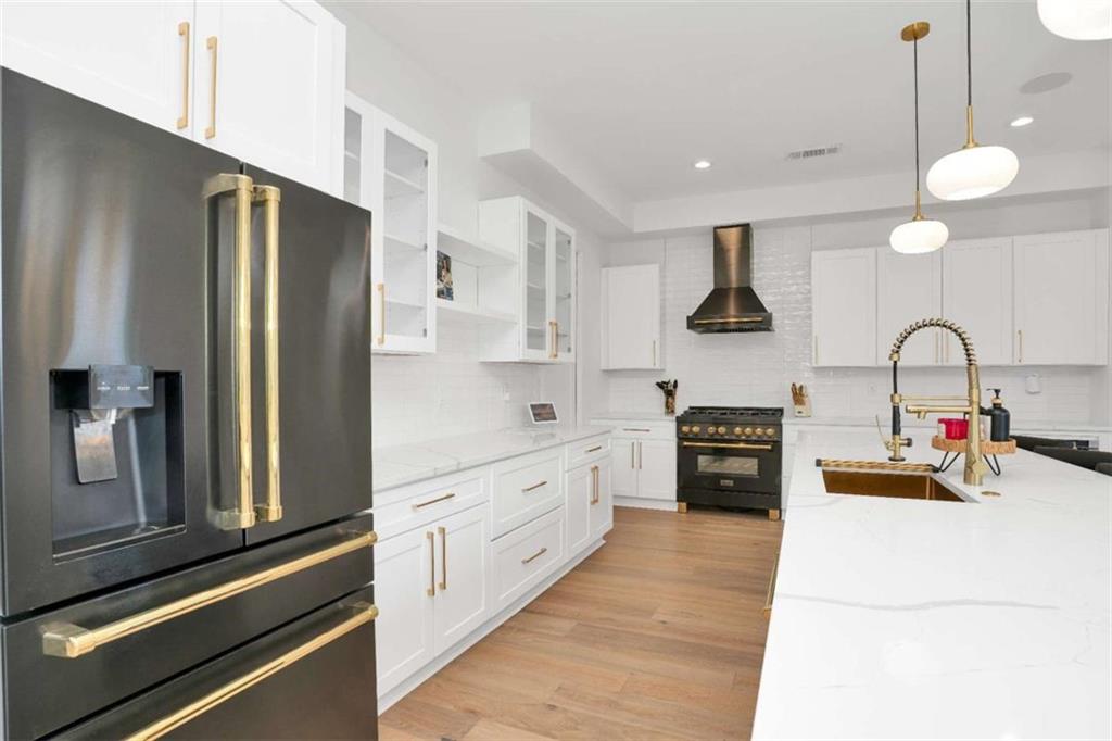 1598 Athens Avenue Southwest Atlanta, GA 30310 - Photo 10 of 45 a kitchen with stainless steel appliances a sink dishwasher a refrigerator and white cabinets with wooden floor