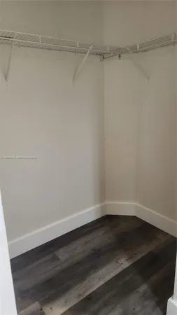 a view of empty room with window and wooden floor